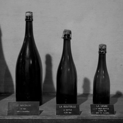 Different Champagne bottle sizes displayed in Maison Taittingers