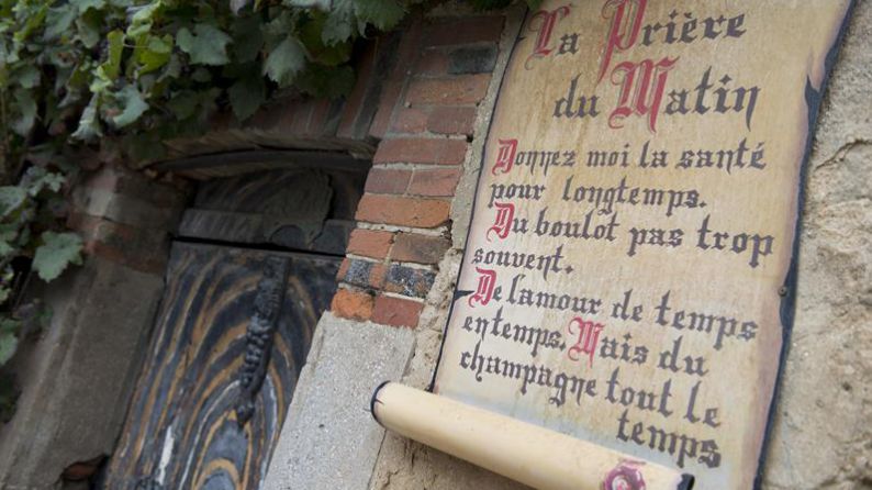 Una puerta antigua en la población de Hautvillers con el mensaje: "Que me den salud durante mucho tiempo. Trabajo no muy a menudo. Amor de vez en cuando. Pero champán siempre."